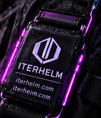An Iterhelm badge on a black strap with magenta lighting.
